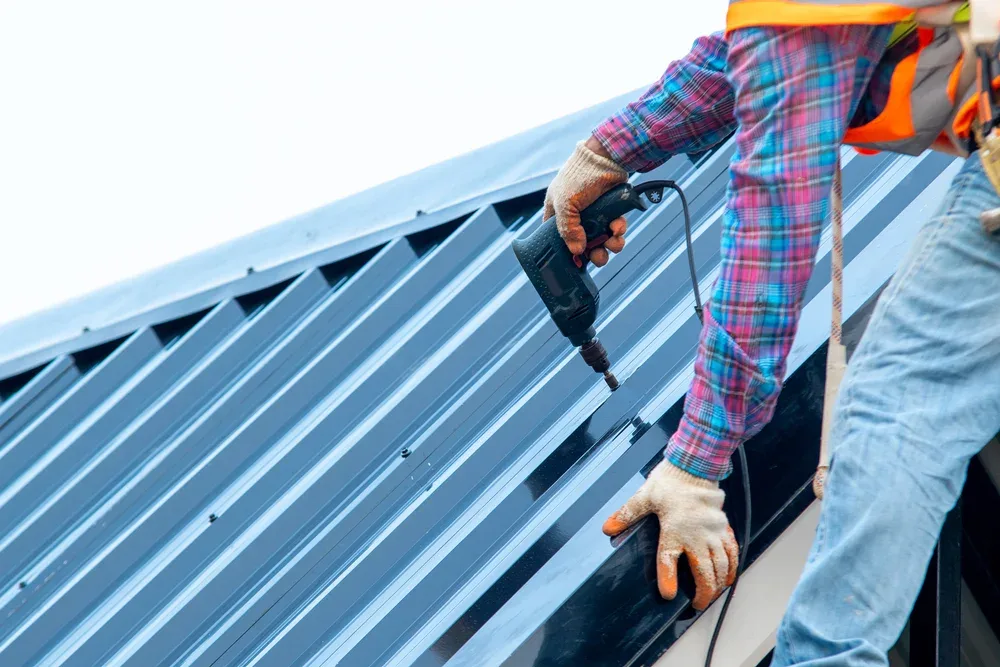 A roofer laying insulation over a new roof deck